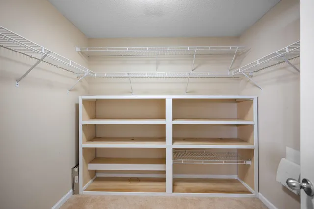 a view of walk in closet with empty racks