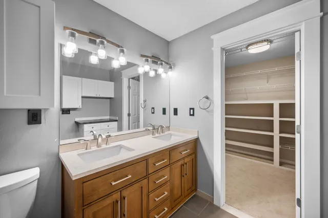 a bathroom with a sink a toilet and a mirror