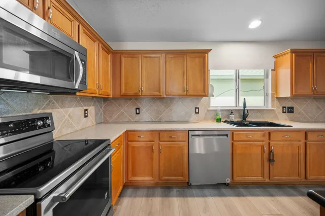 a kitchen with stainless steel appliances a stove a sink and a microwave