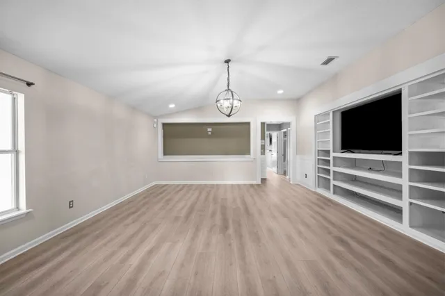 wooden floor in an empty room with a window