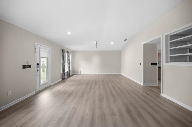 a view of empty room with wooden floor
