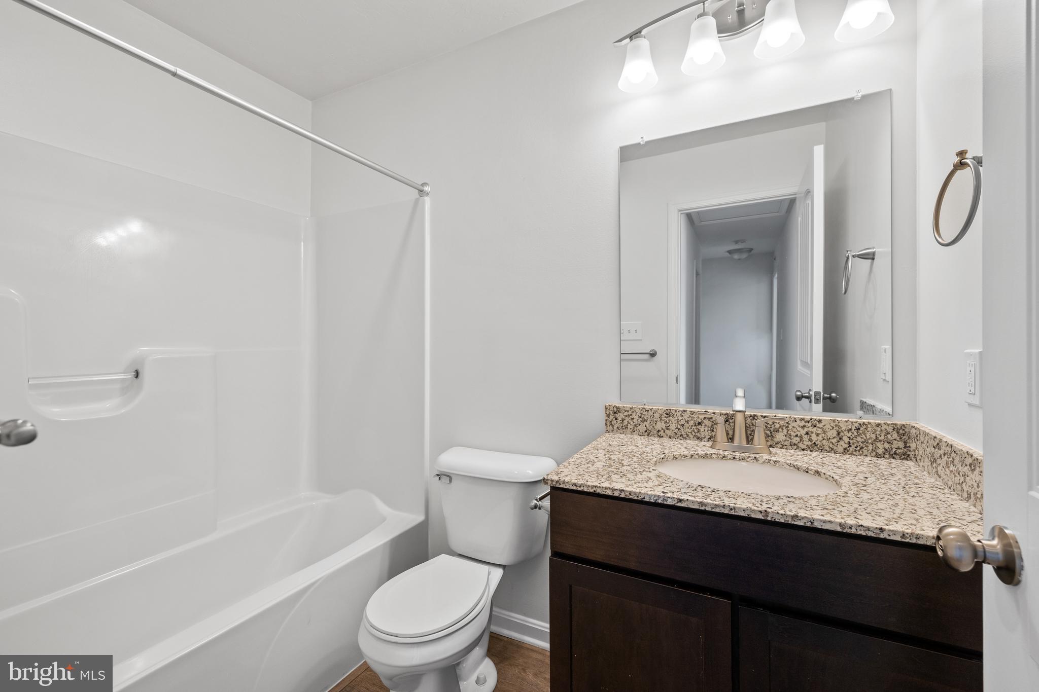 0 H Street, Unit 108 Carlisle, PA 17013 - Photo 16 of 26 a bathroom with a granite countertop sink toilet and shower