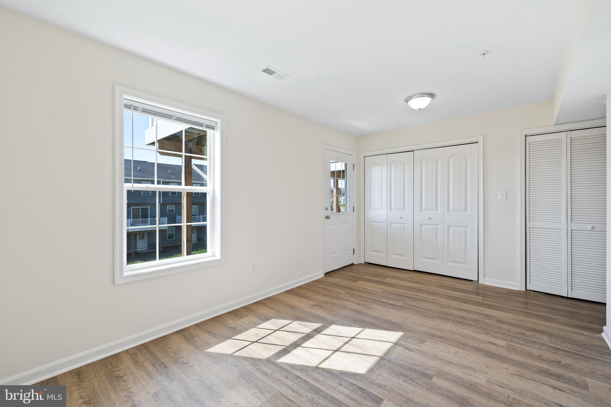 0 H Street, Unit 108 Carlisle, PA 17013 - Photo 23 of 26 a view of an empty room with wooden floor and a window