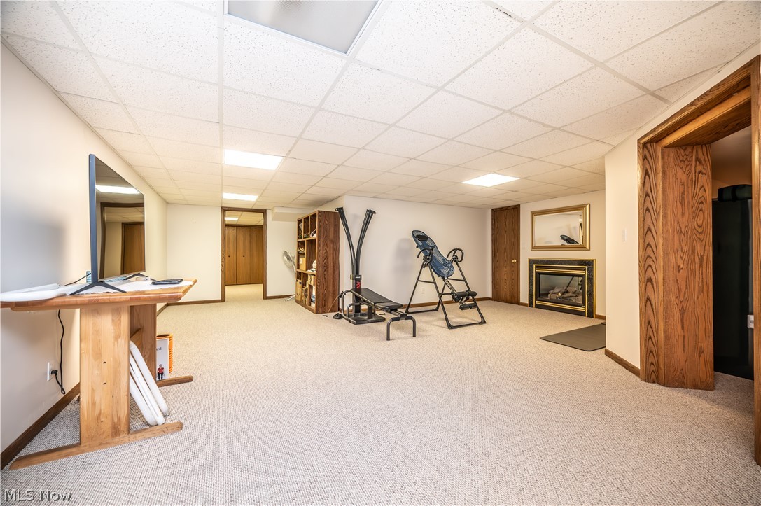 405 Airport Road Northwest Warren, OH 44481 - Photo 34 of 50 Spacious room featuring light-colored carpeting, a built-in fireplace with a dark surround, recessed lighting, and a drop ceiling