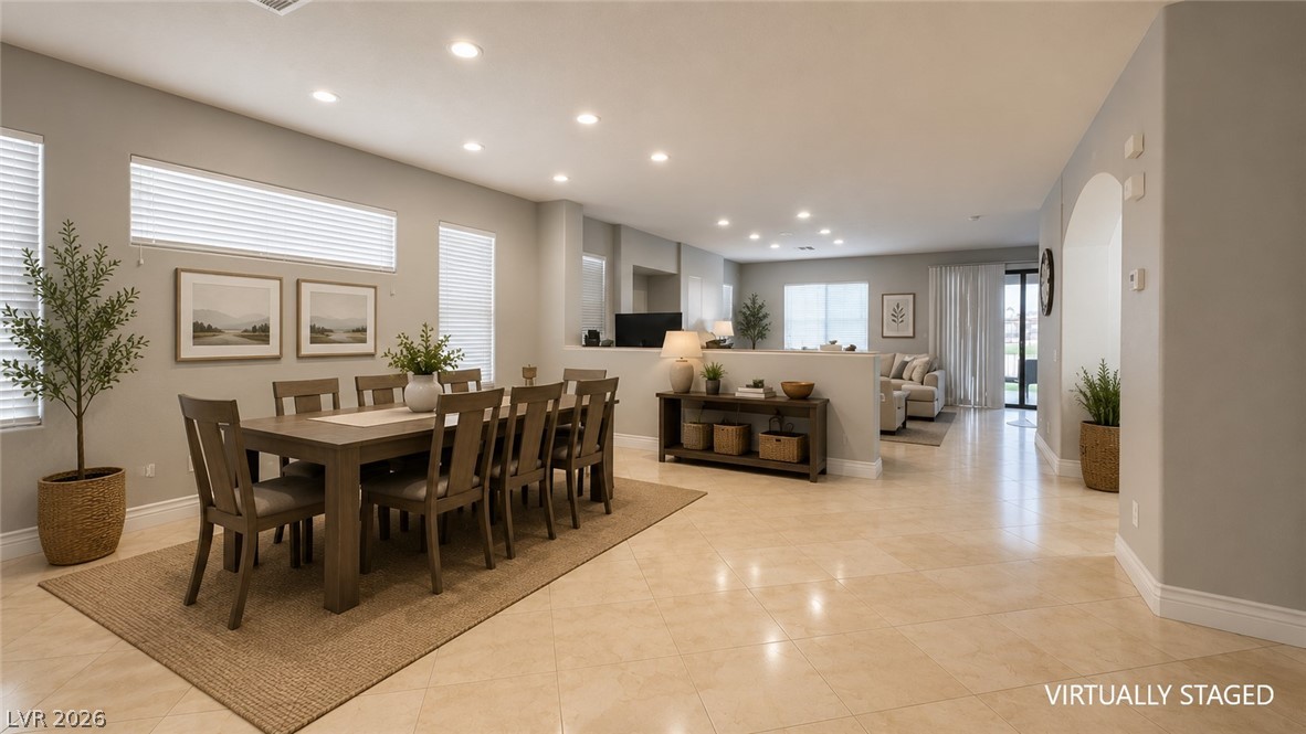 87 Tall Ruff Drive Las Vegas, NV 89148 - Photo 71 of 71 An open floorplan seamlessly connects the dining area to a generous living space, all grounded by elegant tiled flooring.