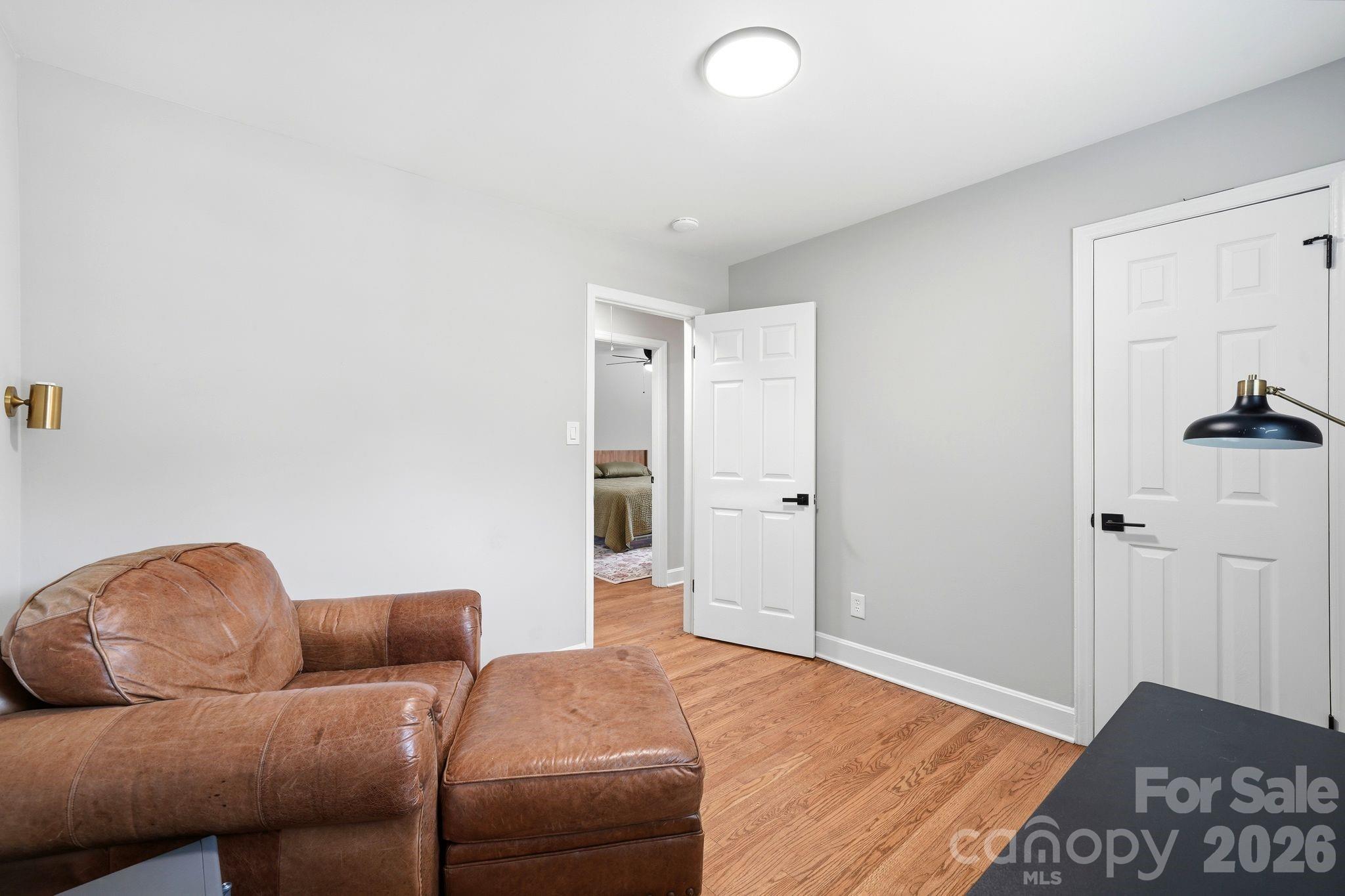 7552 Idlewild Road Charlotte, NC 28212 - Photo 12 of 40 a living room with a couch and a walk in closet with wooden floor