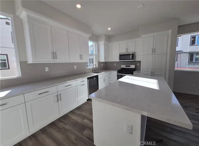 a kitchen with sink a microwave and cabinets