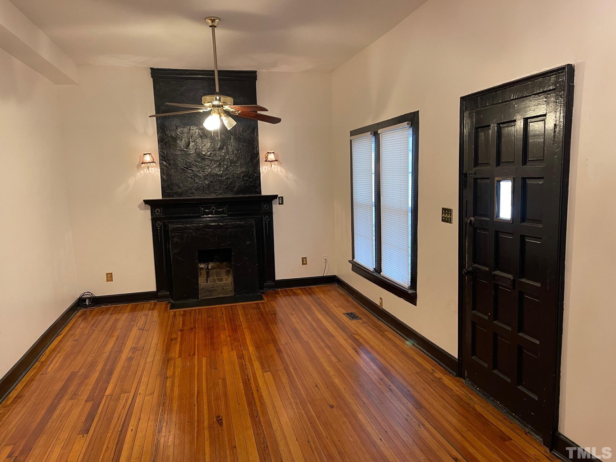 561 New Bern Avenue Raleigh, NC 27601 - Photo 3 of 15 a view of empty room with wooden floor and fireplace
