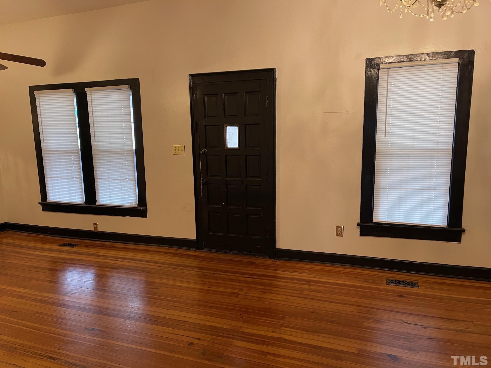 561 New Bern Avenue Raleigh, NC 27601 - Photo 5 of 15 an empty room with wooden floor and windows
