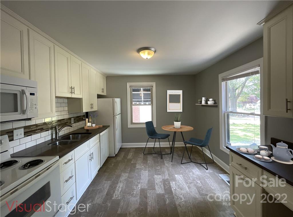 707 Grandin Road Charlotte, NC 28208 - Photo 3 of 19 a kitchen with granite countertop a stove a sink a refrigerator dining table and chairs