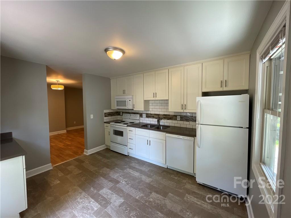 707 Grandin Road Charlotte, NC 28208 - Photo 4 of 19 a kitchen with granite countertop a refrigerator sink stove and cabinets
