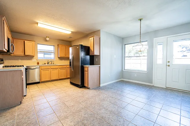 a kitchen with refrigerator cabinets and window