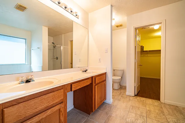 a spacious bathroom with a shower sink and mirror
