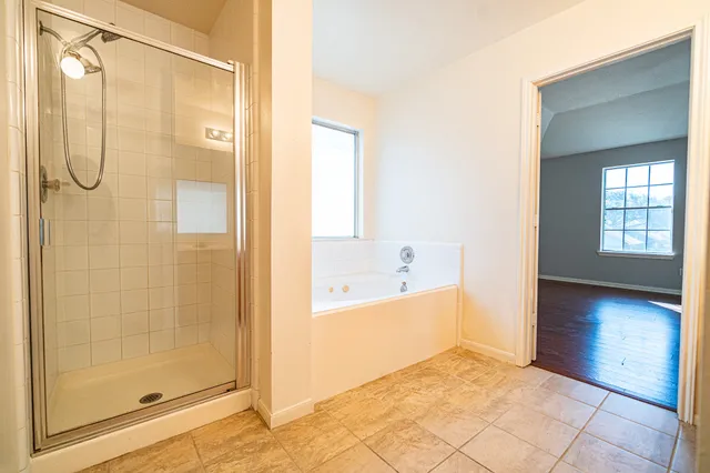 a bathroom with a glass shower door and a bathtub