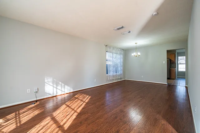 wooden floor in an empty room with a window