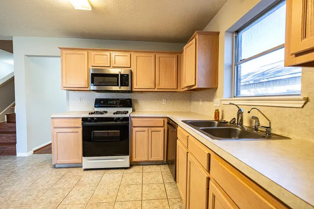 a kitchen with granite countertop a sink and steel appliances