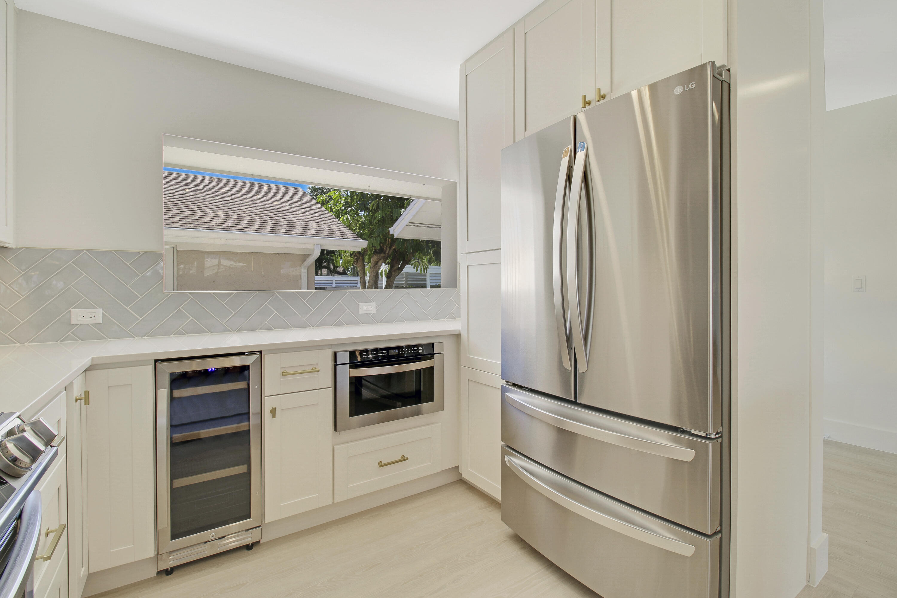 3703 Cape Pointe Circle Jupiter, FL 33477 - Photo 10 of 55 a kitchen with appliances a refrigerator and cabinets