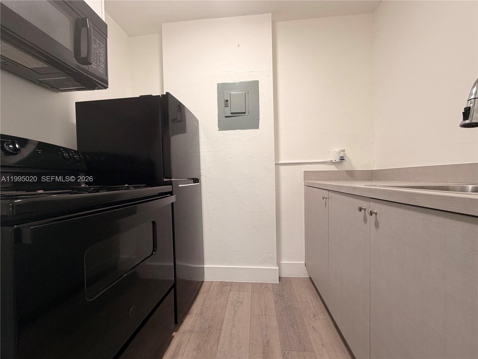 143 Southwest 9th Street, Unit 105 Miami, FL 33130 - Photo 9 of 20 a kitchen with a sink and a stove