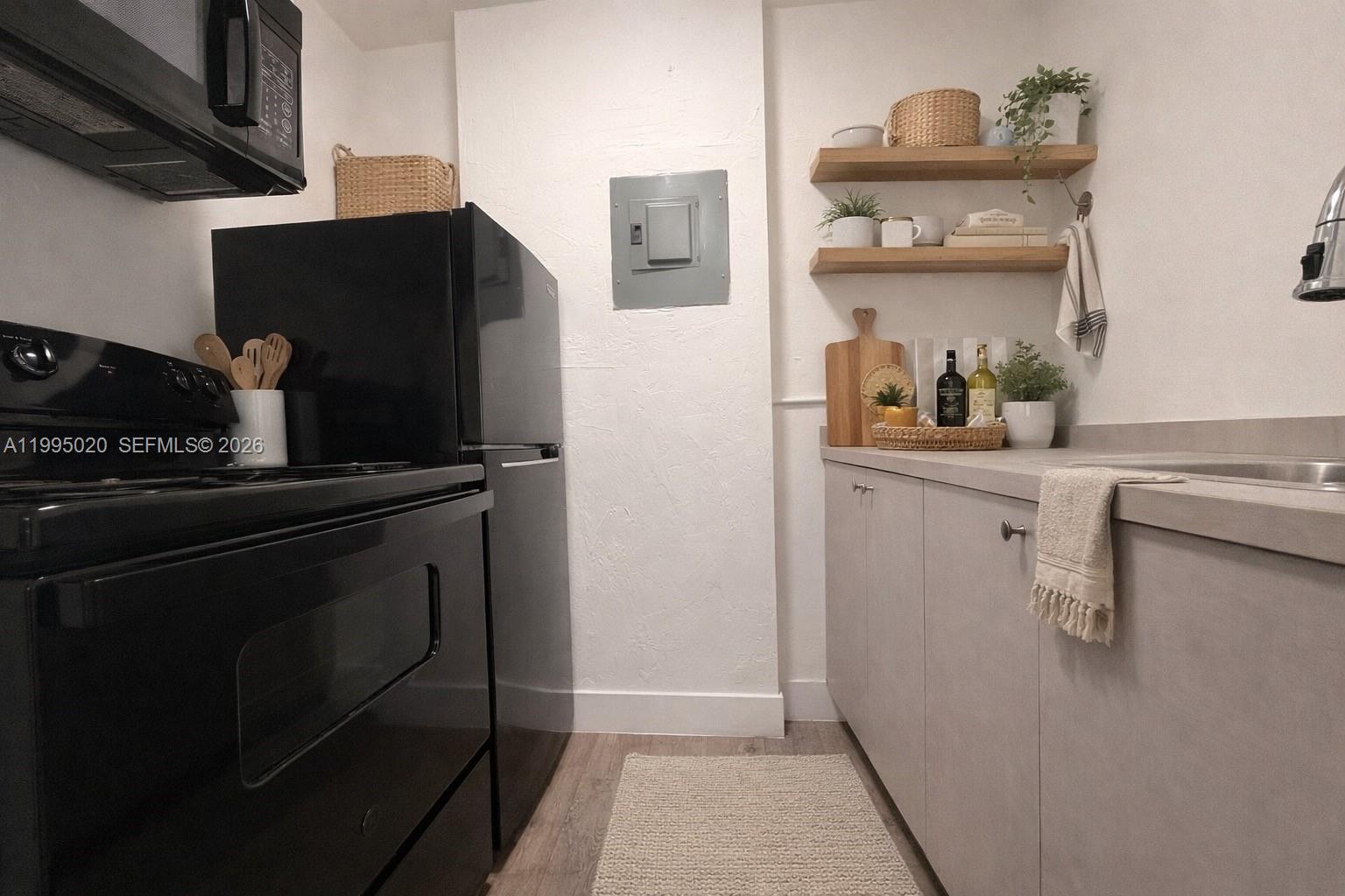 143 Southwest 9th Street, Unit 105 Miami, FL 33130 - Photo 10 of 20 a kitchen with a refrigerator and cabinets