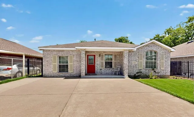 a front view of a house with a garden and plants