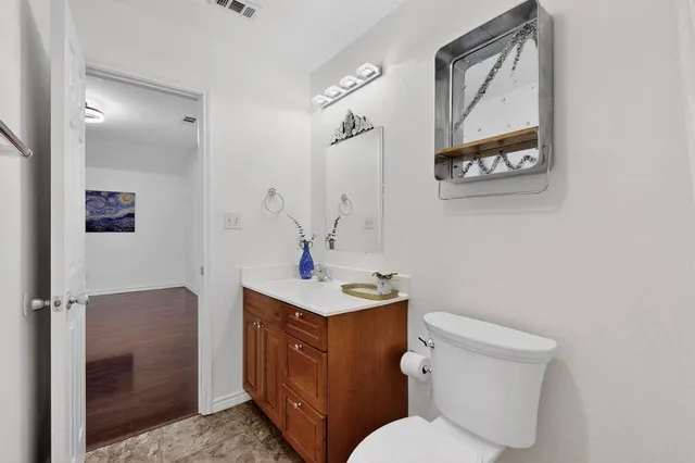 a bathroom with a toilet a sink and mirror