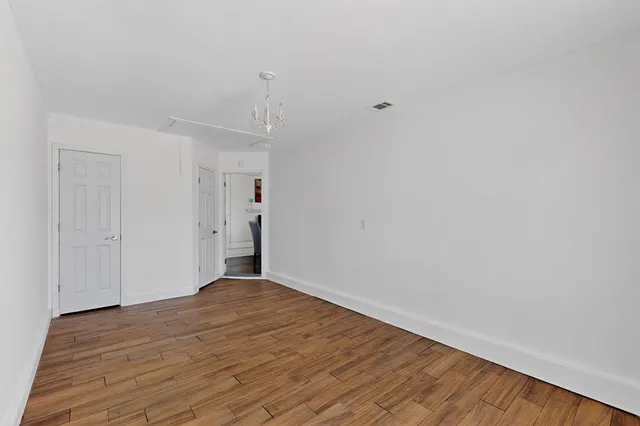 a view of an empty room with wooden floor