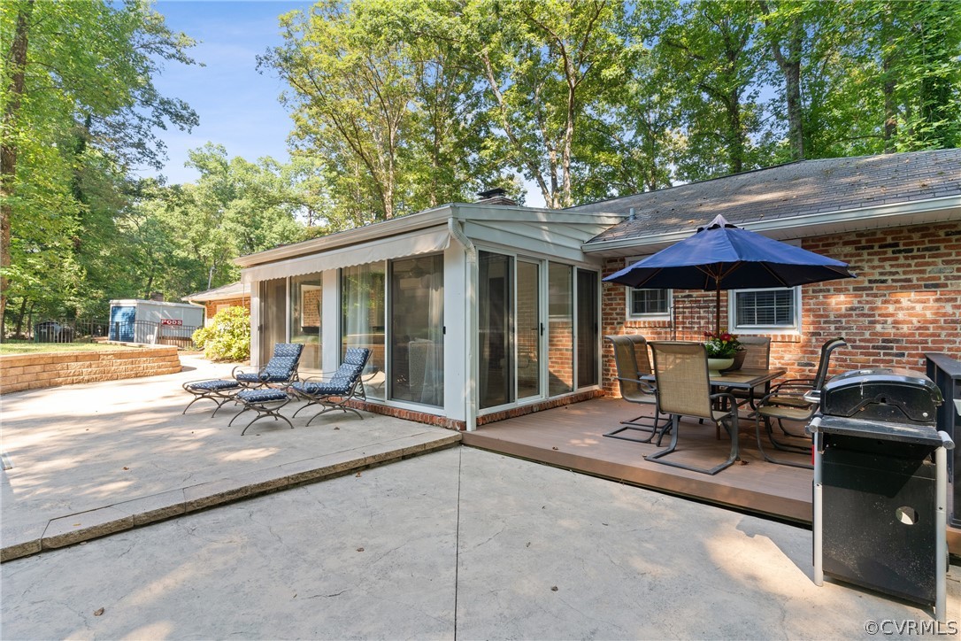 4430 Croatan Road Richmond, VA 23235 - Photo 36 of 44 a patio with a table and chairs under an umbrella