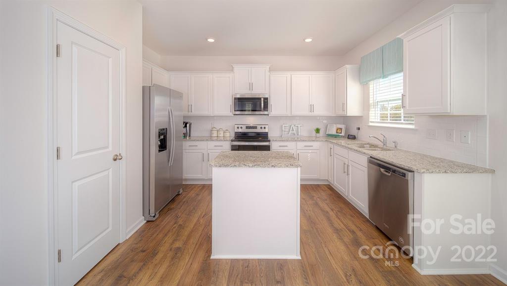 309 Gaines Road Clover, SC 29710 - Photo 23 of 48 a kitchen with stainless steel appliances granite countertop a refrigerator a sink dishwasher a stove and white countertops with wooden floor