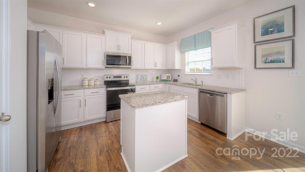 309 Gaines Road Clover, SC 29710 - Photo 24 of 48 a kitchen with stainless steel appliances granite countertop a stove top oven a sink a refrigerator white cabinets and wooden floor