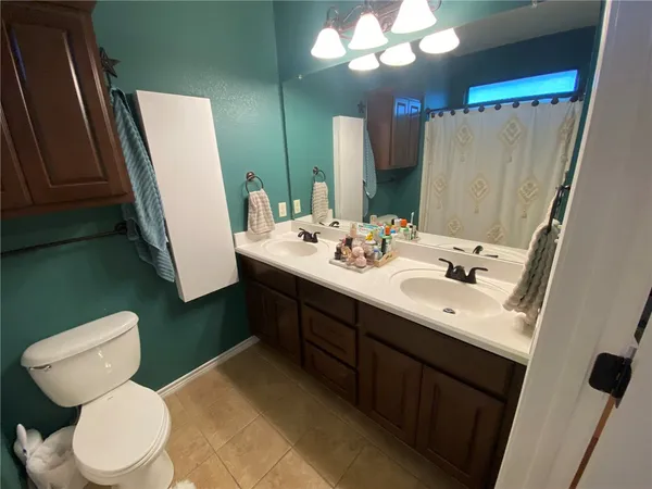 a bathroom with a sink a toilet a mirror and vanity