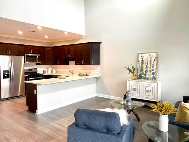 a living room with stainless steel appliances kitchen island granite countertop furniture and a view of kitchen