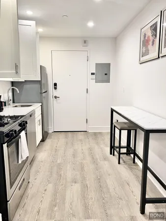 a view of kitchen with stainless steel appliances wooden floor and a refrigerator