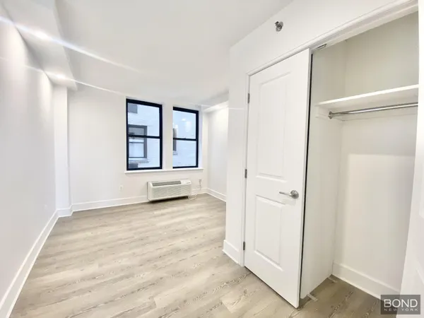 an empty room with windows and closet