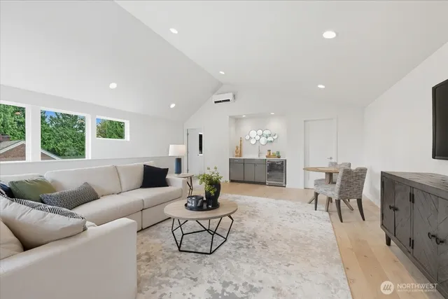 a living room with furniture kitchen view and a large window