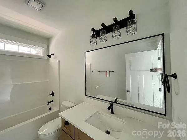 a bathroom with a tub sink and mirror