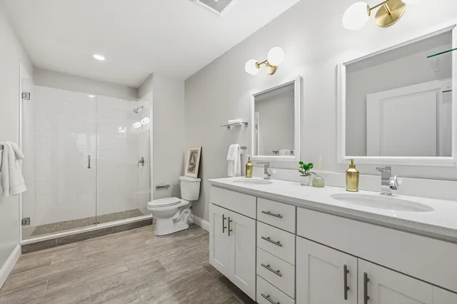 a spacious bathroom with a double vanity sink toilet and shower