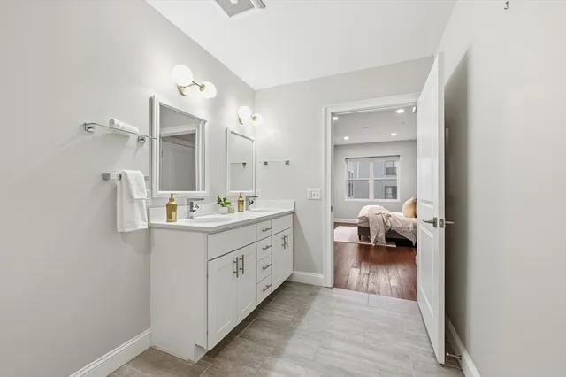 a en suite bathroom with a double vanity sink and a mirror