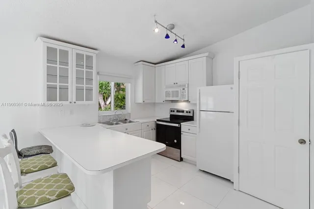 a kitchen with a refrigerator a stove a sink and a dining table