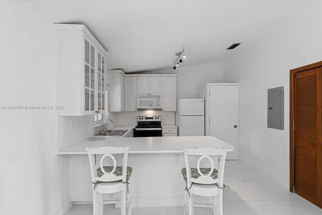 a kitchen with stainless steel appliances a white table and chairs
