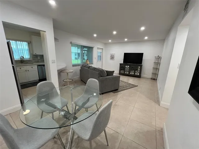 a living room with furniture a flat screen tv and wooden floor