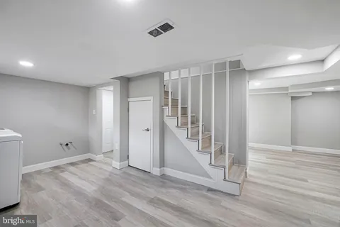 an empty room with wooden floor and entryway