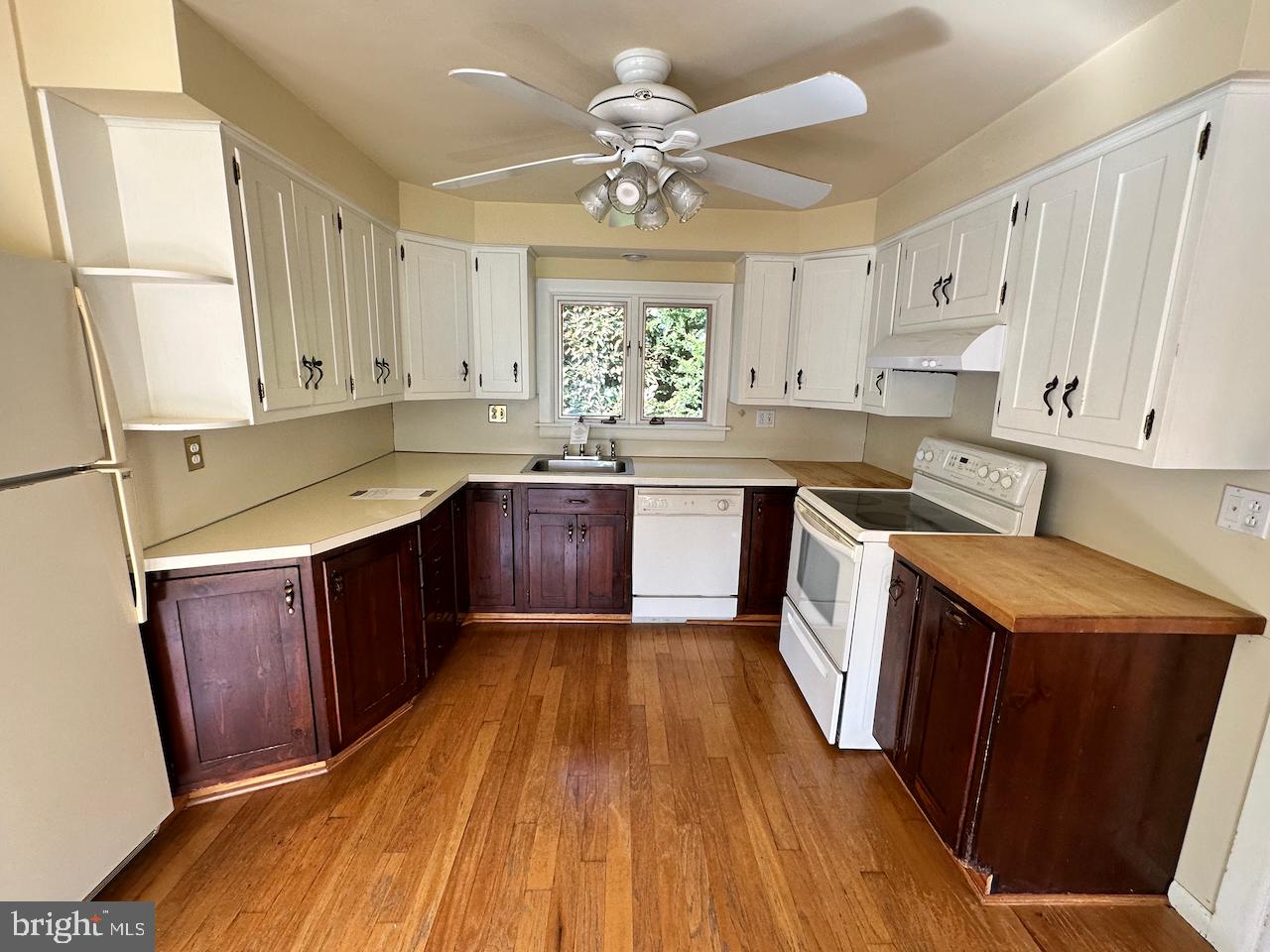 61 Devon Road Paoli, PA 19301 - Photo 4 of 25 a kitchen with wooden floors and white cabinets