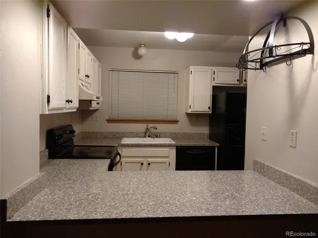 a living room with stainless steel appliances kitchen island granite countertop furniture and a refrigerator