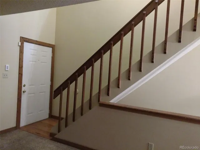 a view of staircase with lots of frames on wall