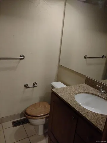 a bathroom with a granite countertop sink a toilet and a mirror