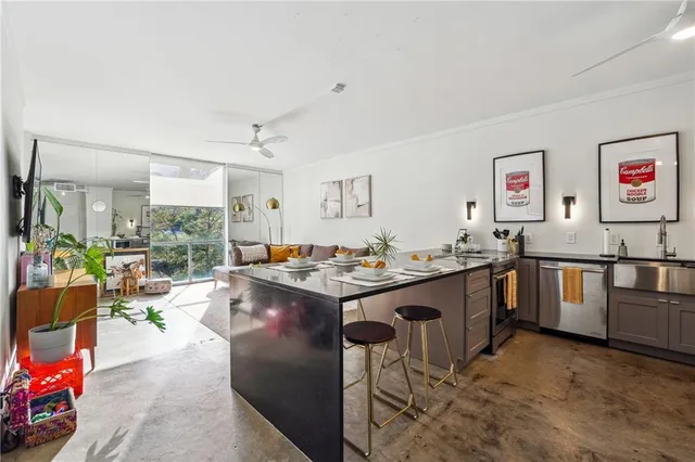 a view of kitchen with stainless steel appliances granite countertop a sink stove and a refrigerator