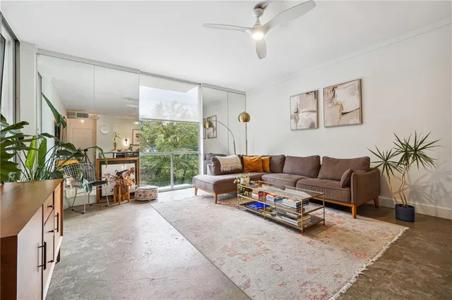 a living room with furniture a flat screen tv and a large window