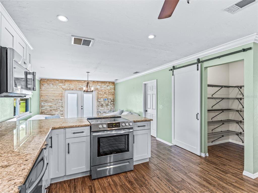 2405 Southeast 157th Lane Road Summerfield, FL 34491 - Photo 15 of 35 a kitchen with a stove and a wooden floor