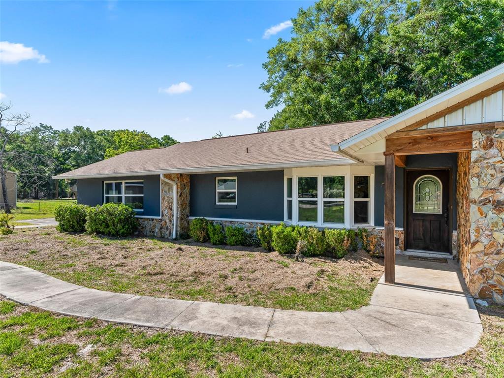 2405 Southeast 157th Lane Road Summerfield, FL 34491 - Photo 5 of 35 a front view of a house with garden and porch