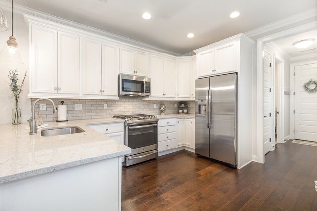 a kitchen with a refrigerator sink and cabinets